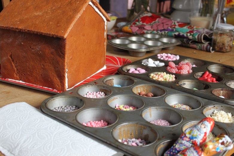 Dekorations Süßigkeiten für Lebkuchenhaus in Muffinblecht sortieren.